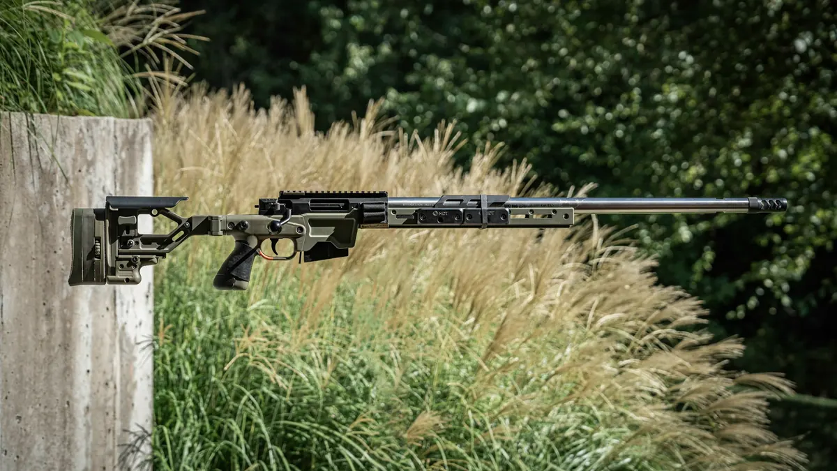 Jungjäger prüft eine Repetierbüchse mit Holzschaft im Fachgeschäft