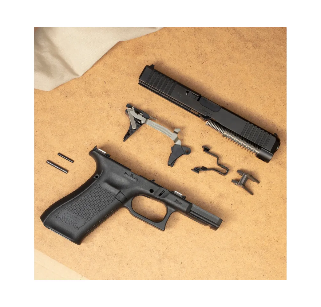 Glock Performance Trigger neben zerlegtem Griffstueck und Verschluss einer Glock